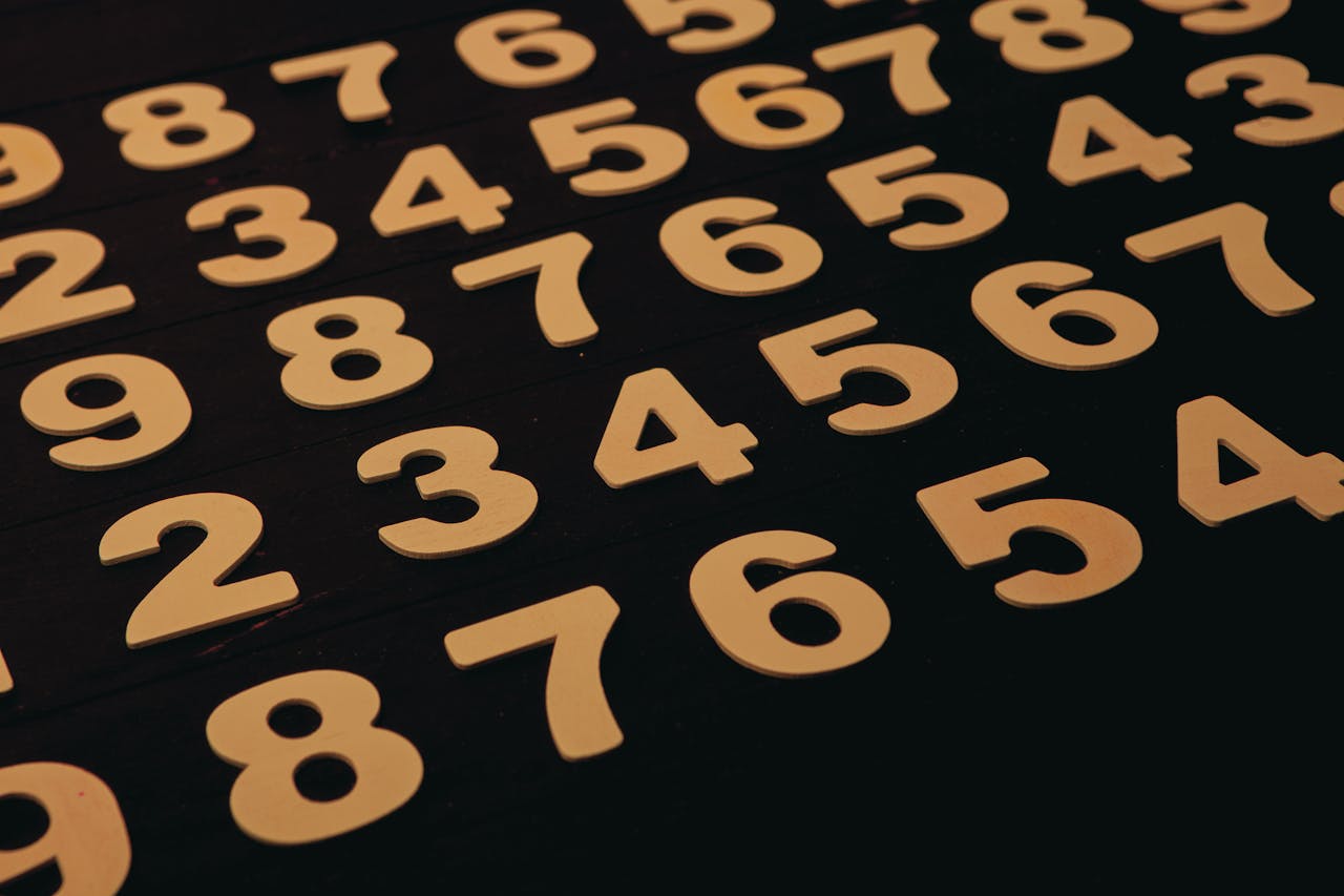 Close-up view of wooden numbers arranged on a black surface, ideal for educational themes.