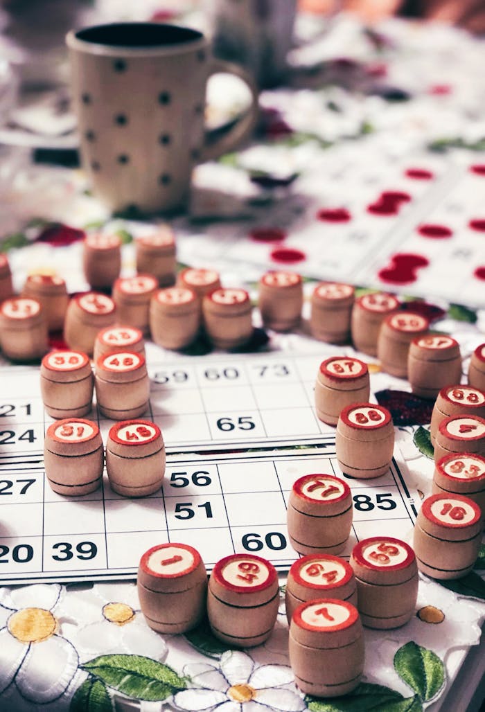 Vintage bingo game with wooden chips on a floral table. Cozy indoor setting.